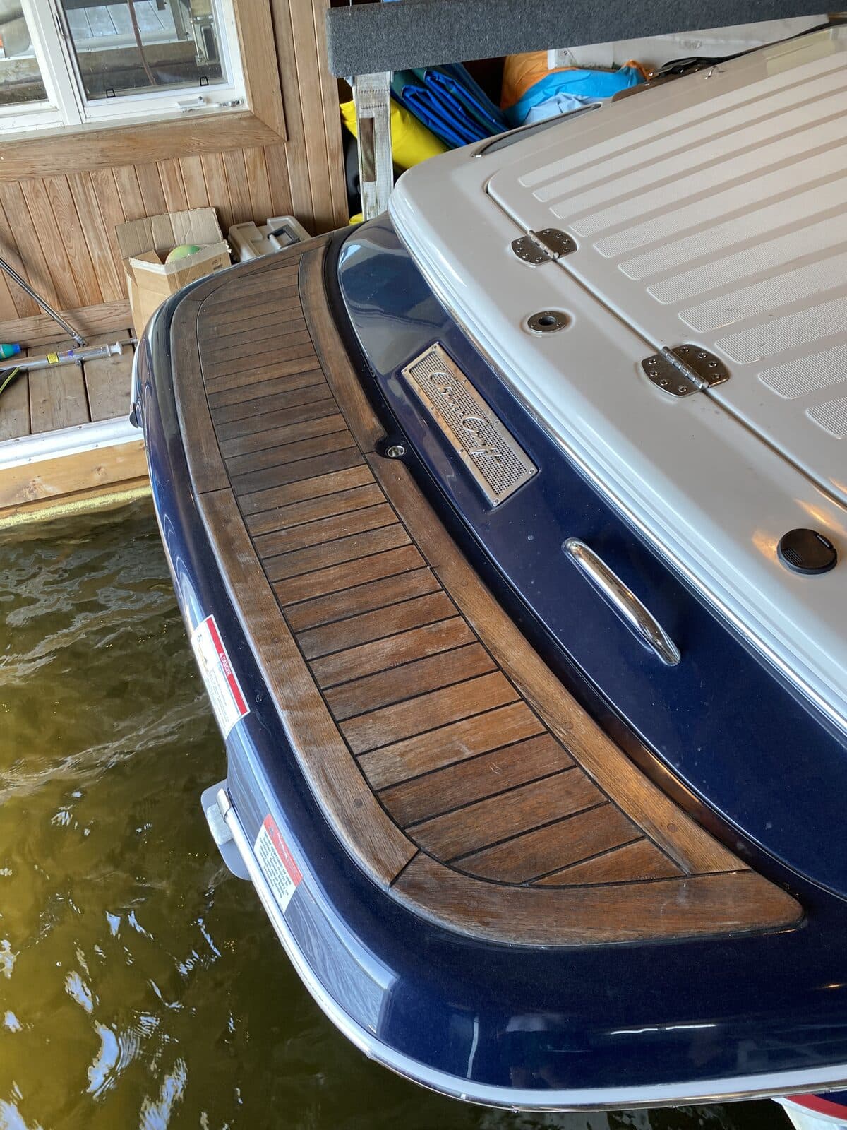Polished navy boat hull with teak swim platform